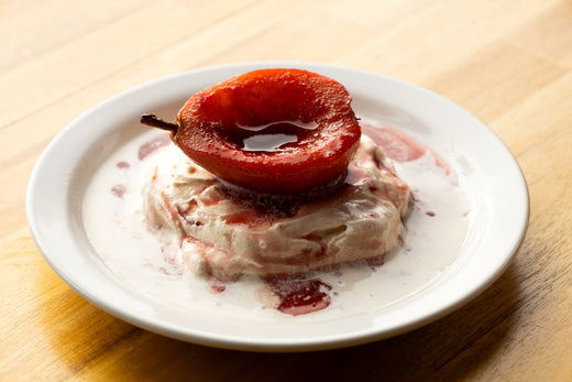 A finished poached pear on ice cream