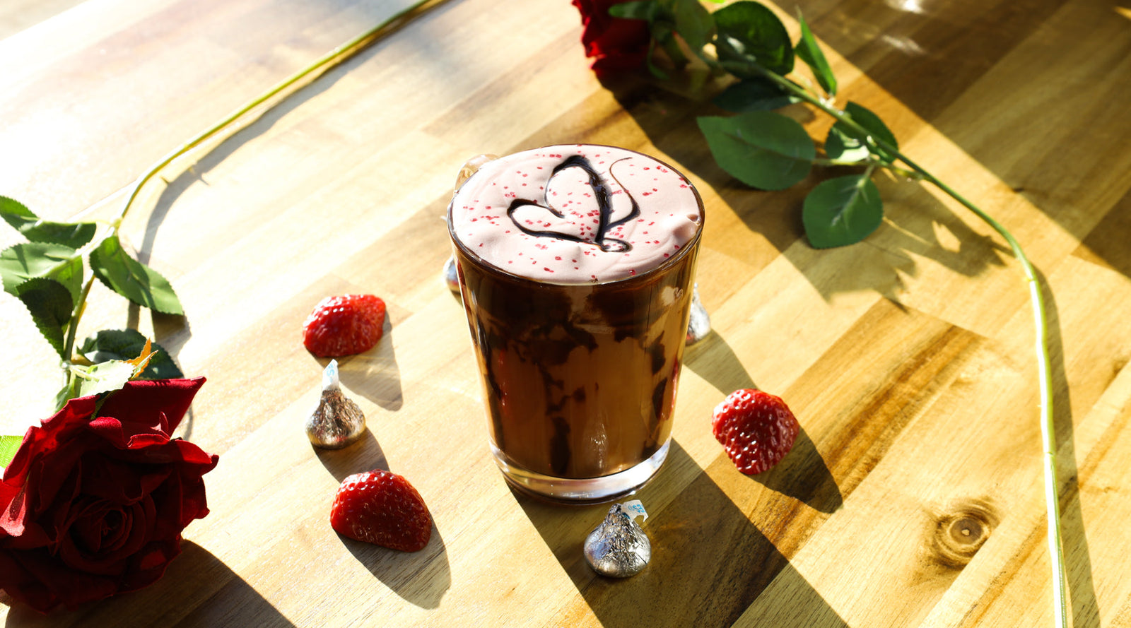 A glass of iced belgian chocolate tea topped with strawberry cold foam