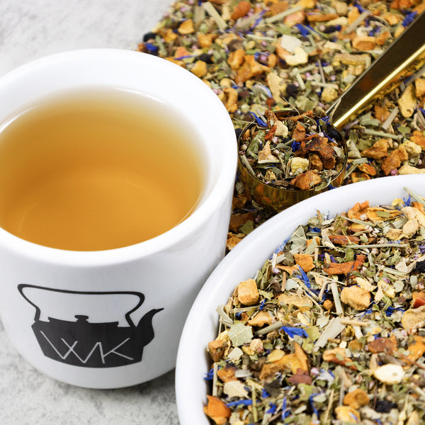 Bowl of Ginger Blueberry loose leaf tea next to cup of brewed Ginger Blueberry.