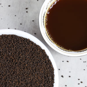 Cup of Irish Breakfast tea next to bowl of Irish Breakfast tea leaves.