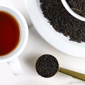 Cup of brewed Lovers Leap next to bowl of Lovers Leap loose leaf tea.