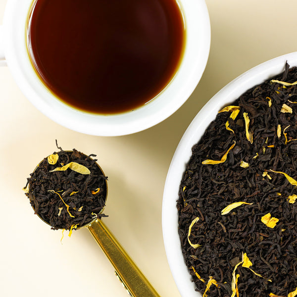 Cup of Monk's Blend tea next to bowl of Monk's Blend loose leaf tea.