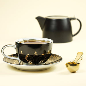 Cup & Saucer set filled with brewed Orchard Spice Nectar tea next to Gold Tea Scoop filled with loose leaf Orchard Spice Nectar.