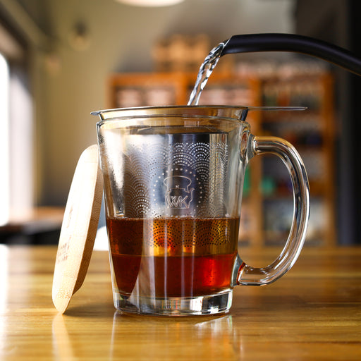 The Whistling Kettle "The Steepster" Stainless Steel Tea Infuser with Bamboo Top in cup.