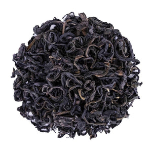 Top mound picture of The Whistling Kettle Purple Whole Leaf tea with curly dark leaves.